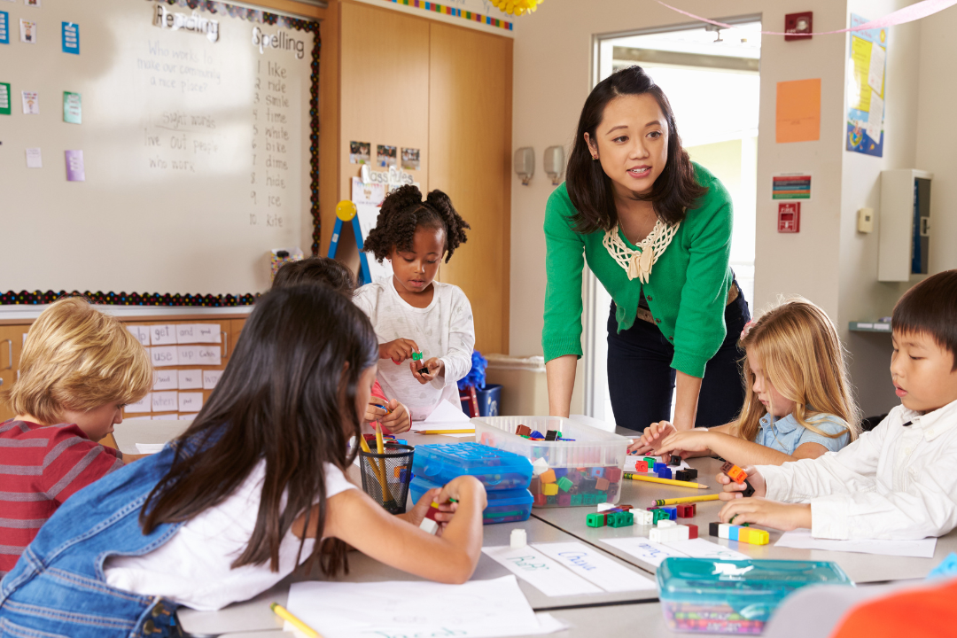 Teacher providing feedback to group of young students